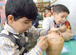 دو کودک ایرانی در حال نقاشی بر روی قلک