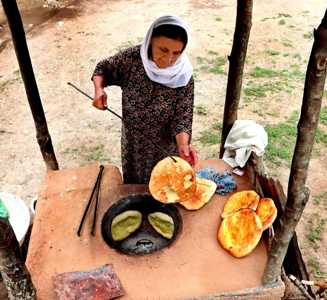 زن تالشی در حال بخت نان در تنور تالشی