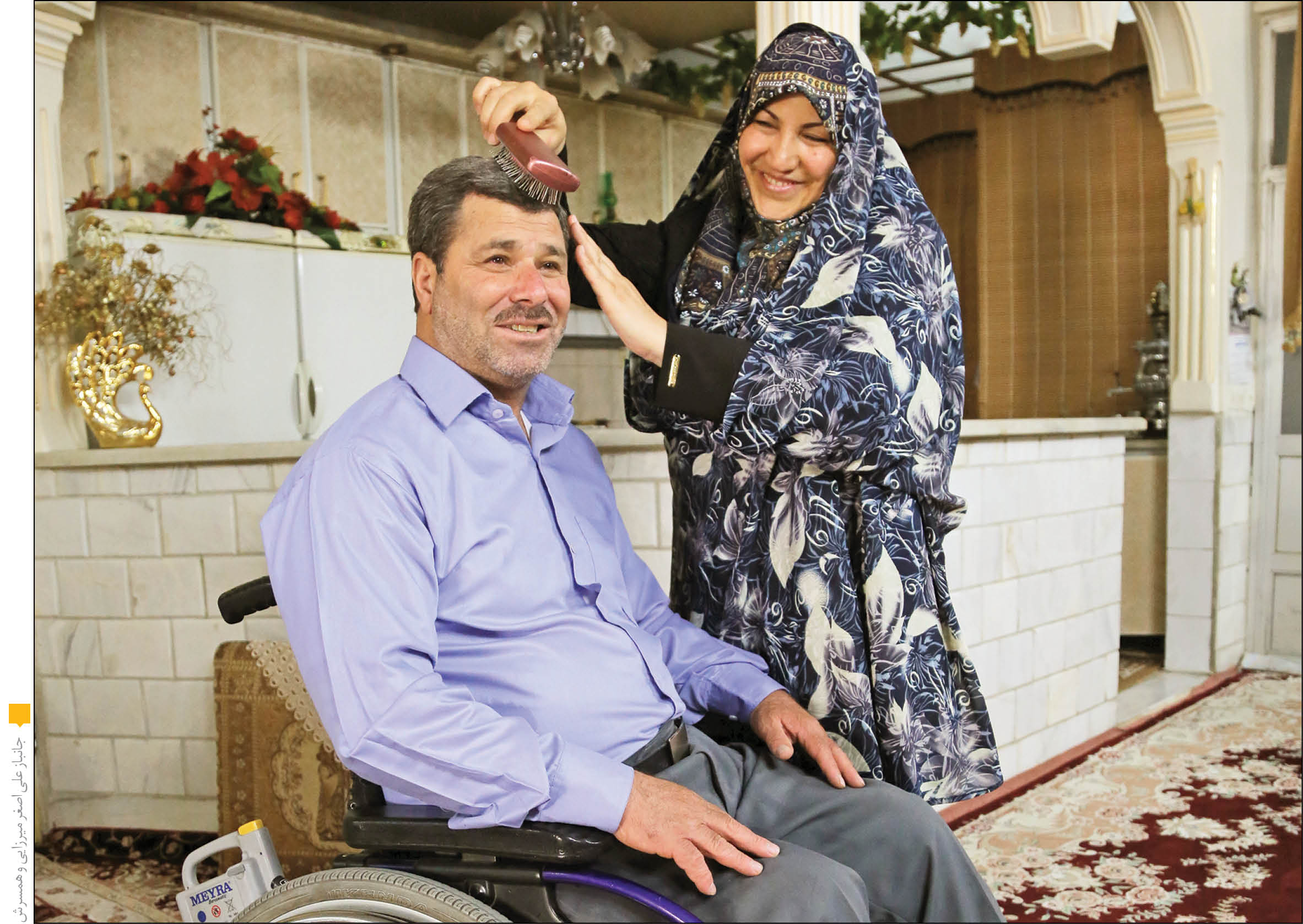 صدیقه‌سادات حسینی در حال شانه‌کردن موهای همسرش علی‌اصغر میرزایی، جانباز ۷۵ درصد