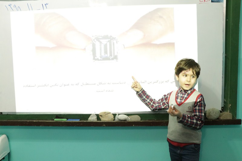 دانش‌آموز کلاس چهارم ابتدایی در حال ارائه کنفرانس در کلاس درس