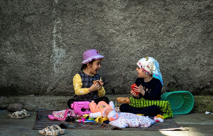 روشا و نیلوفر دو دختر ایرانی در حال خاله بازی در یکی از محله‌های تهران