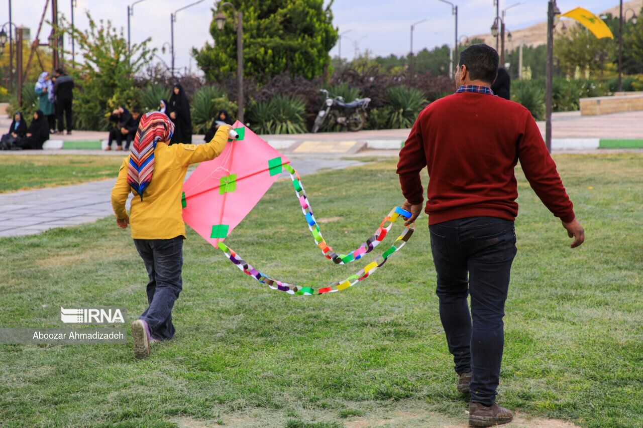 پدر و دختر در حال آماده سازی برای پرواز دادن بادبادک